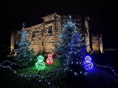 Colchester Castle at night, with a Christmas display of lights in front of it